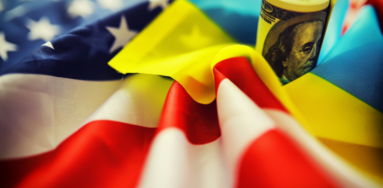 American and Ukrainian flags with a roll of American dollars