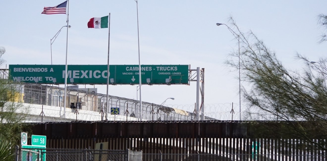 View of the U.S.-Mexico Border Wall with the Mexico border checkpoint on the Bridge of the Americas International Bridge in the background