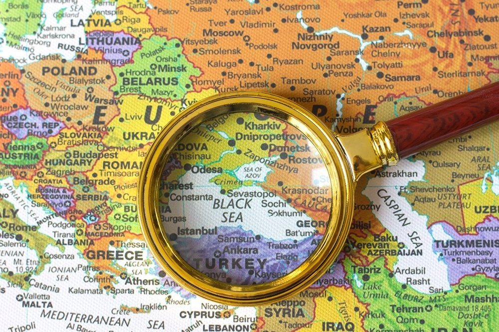 A looking glass centered over a map of the Black Sea.