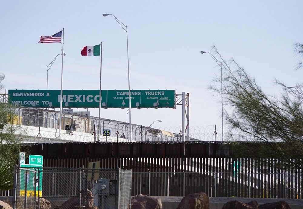 View of the U.S.-Mexico Border Wall with the Mexico border checkpoint on the Bridge of the Americas International Bridge in the background