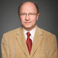 John Packer is pictured in front of a grey background.