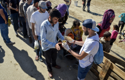 Refugees waiting in line for food.