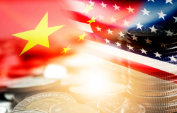 American and Chinese flags above a stack of coins